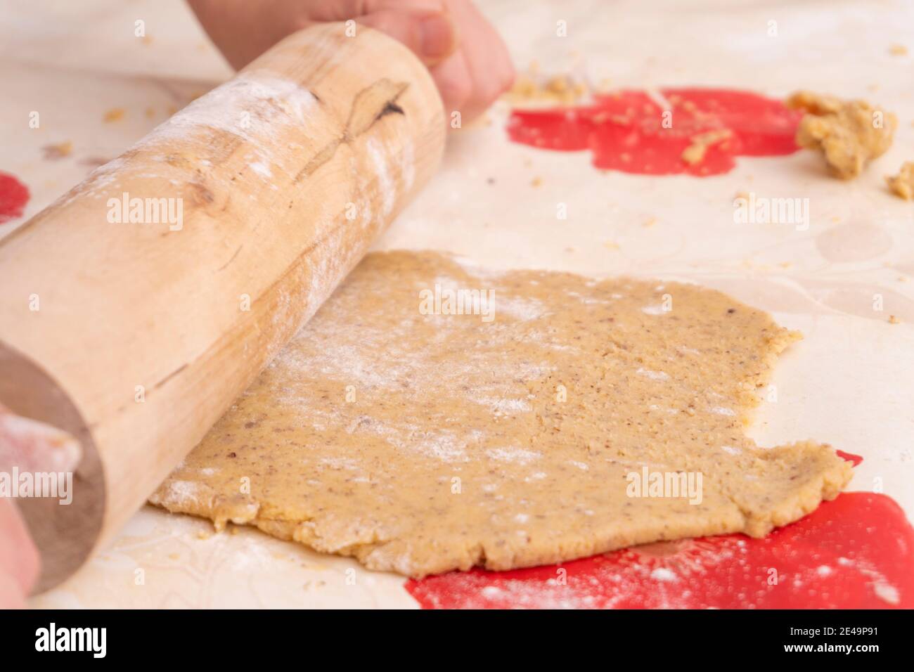 Giovane donna che fa la panetteria tedesca di natale a casa in cucina, rullo di pasta arrotolabile a mano, Foto Stock