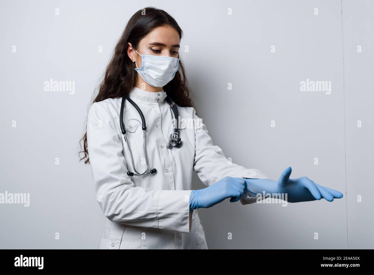 Chirurgo che indossa guanti medici. Bella ragazza in maschera medica si  prende cura della sua igiene. Preparazione prima dell'intervento plastico  in clinica medica Foto stock - Alamy