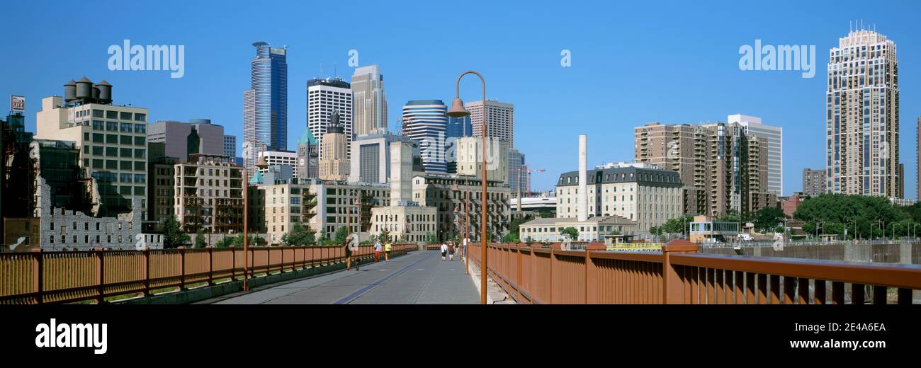 Ponte ad arco in pietra con grattacieli sullo sfondo, Minneapolis, Minnesota, USA Foto Stock