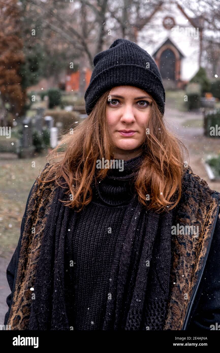 poratrito di giovane bruna triste che cammina da sola nel cimitero Foto Stock