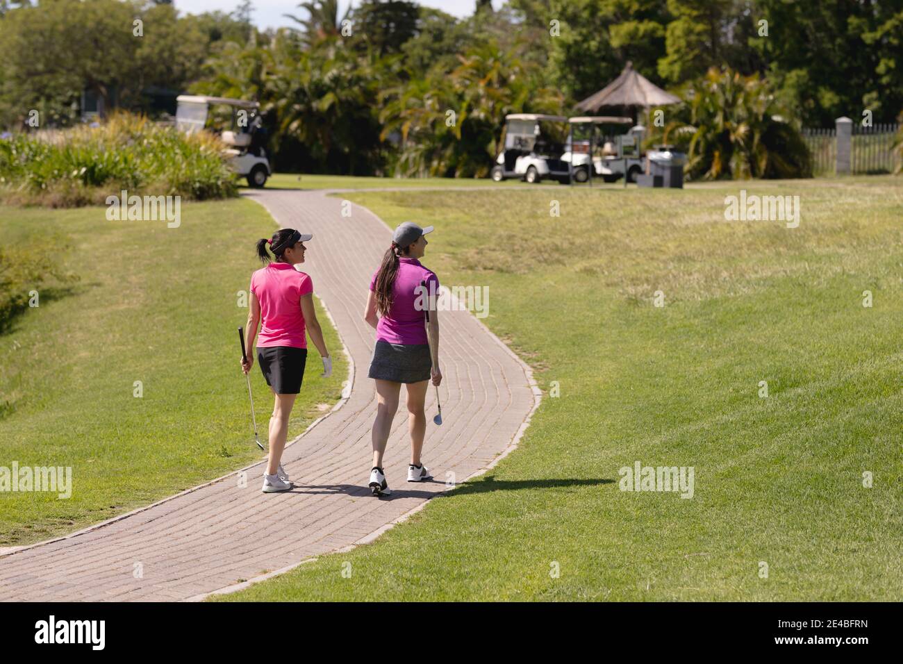 Due donne caucasiche che giocano a golf camminando sul percorso a golf corso Foto Stock