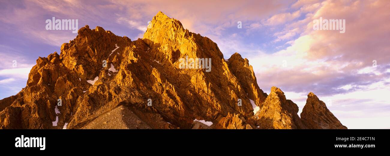 Vista ad angolo basso della vetta della montagna al tramonto, Teton Range, Grand Teton National Park, Wyoming, USA Foto Stock