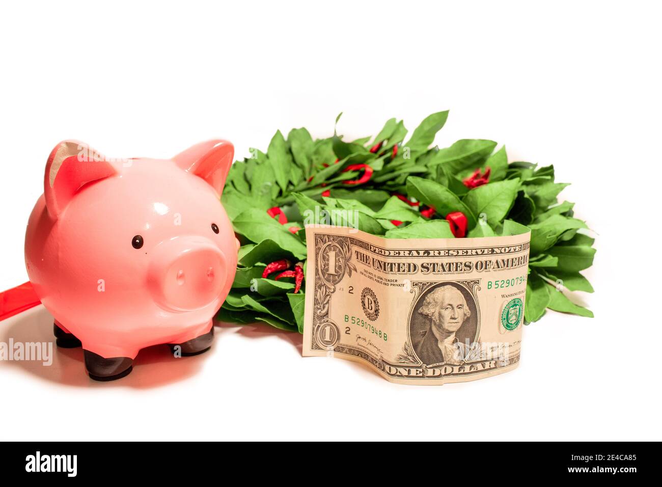 Piggy bank isolato sfondo bianco con una banconota da dollaro americano e trionfale corona di alloro Foto Stock