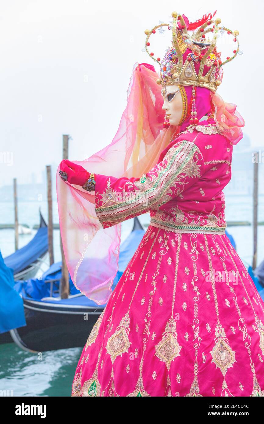 Italia, Veneto, Venezia, donna in costume rosa al carnevale di venezia, mattina foggy nella laguna veneta Foto Stock