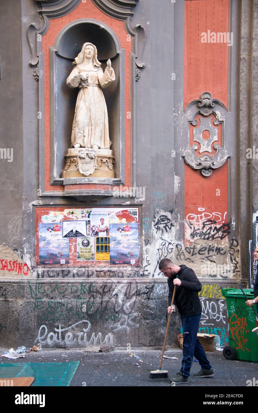 Napoli, facciata della chiesa con manifesti e graffiti, spazzatrici in primo piano Foto Stock