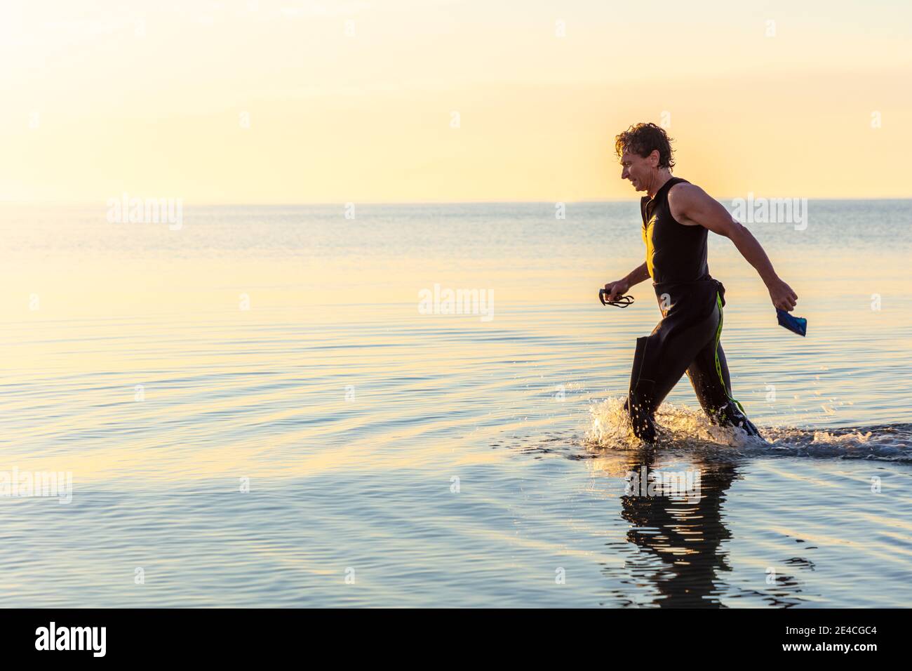 Man 50 Plus FIT, con una muta in mare. Dopo l'allenamento triathlon al mattino nel Mar Baltico Foto Stock