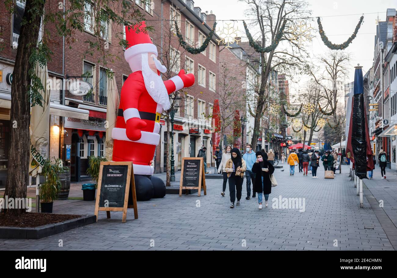 Duesseldorf, Nord Reno-Westfalia, Germania - vuota la città vecchia di Duesseldorf con Babbo Natale in tempi della crisi della corona durante la seconda parte del blocco, i passanti con maschere protettive portano il loro cibo da asporto a casa. Foto Stock