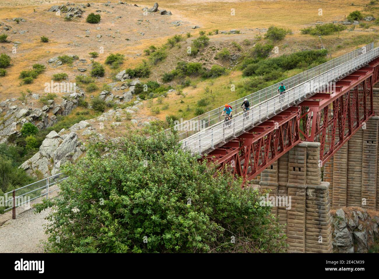 Tre persone in bicicletta lungo il Central Rail Trail di Otago sul Viadotto di Poolburn, Isola del Sud, Nuova Zelanda Foto Stock