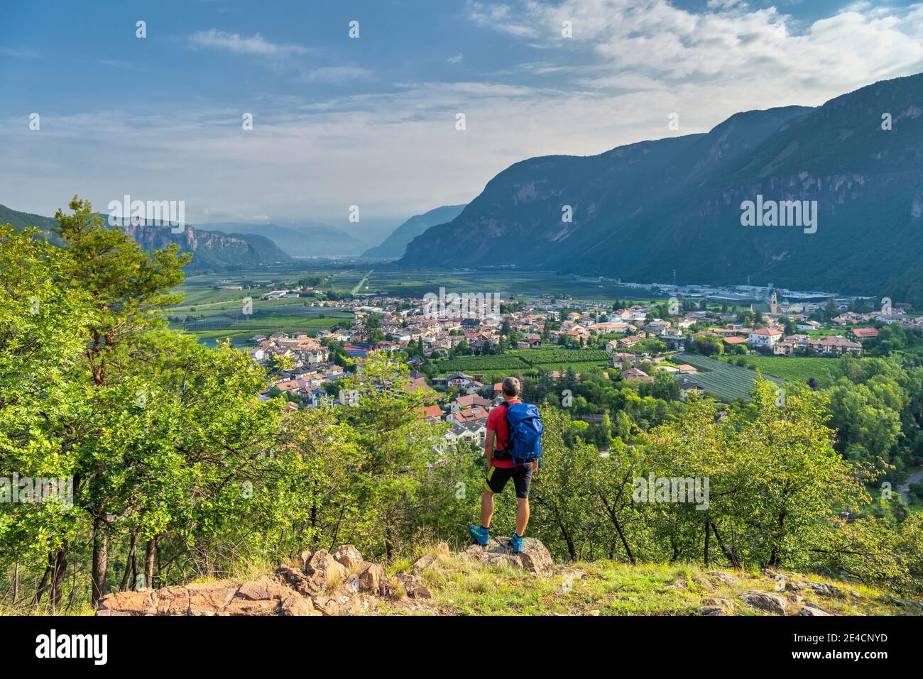 Montan, Provincia di Bolzano, Alto Adige, Italia. Un escursionista sulla salita alla collina di Castelfeder, dove si incontrano tracce di preistoria e di alto insediamento medievale. Nella valle il villaggio di Auer Foto Stock