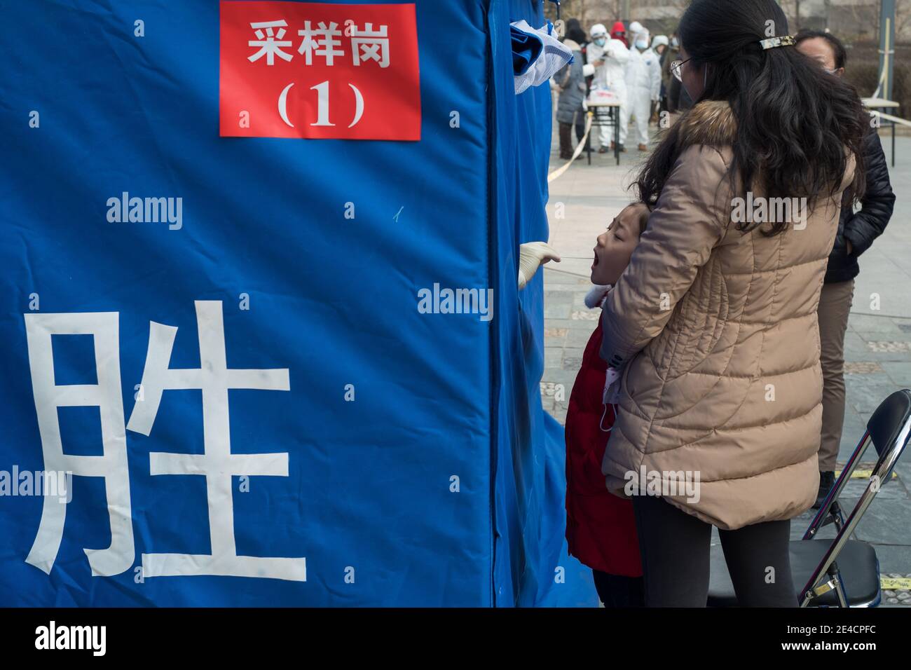 Il medico raccoglie un tampone dalla ragazza per il test degli acidi nucleici, a seguito di nuovi casi del coronavirus a Pechino, Cina 23 gennaio 2021. Foto Stock
