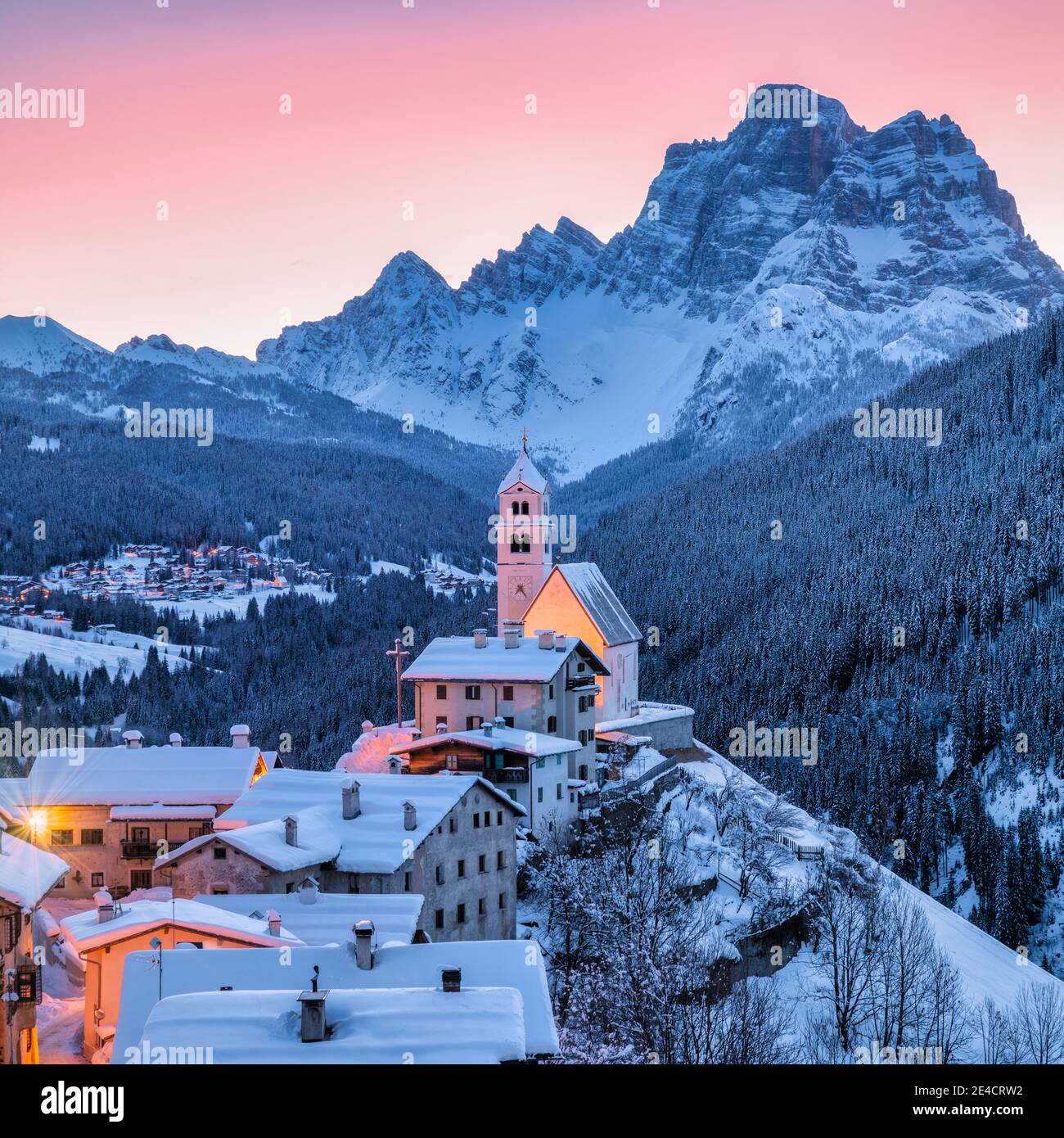 Italia, Veneto, Belluno, Agordino, villaggio alpino di Colle Santa Lucia in inverno all'alba, case e chiesa illuminate, Dolomiti Foto Stock