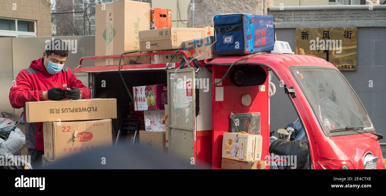 Il delivery man di JD scansiona scatole di cartone con un lettore di codici a barre a Pechino, Cina, gennaio 23. 2021. Foto Stock