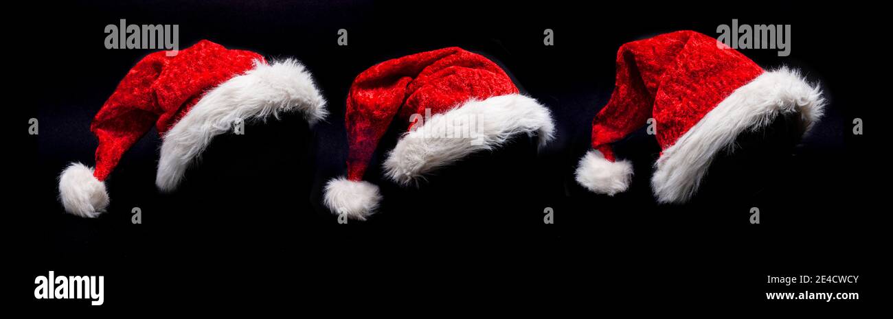 Tre cappelli di Natale su sfondo nero Foto Stock