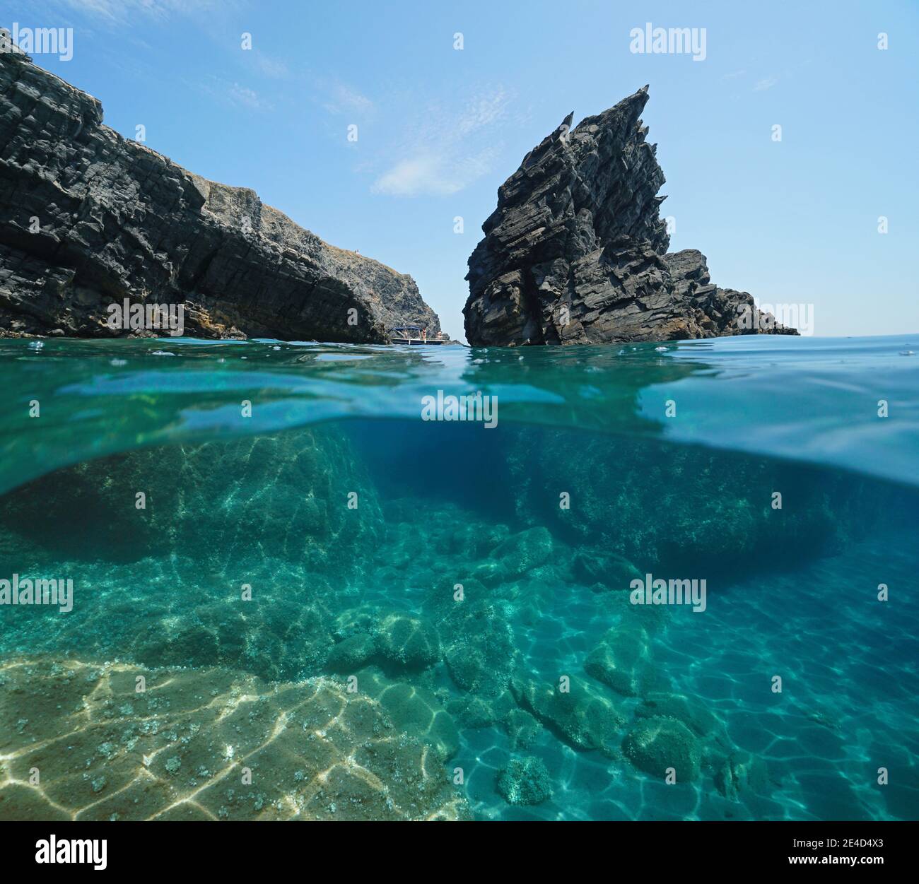 Mare Mediterraneo, rocce aspre e costa rocciosa, vista a metà su e sotto l'acqua, Cap Cerbere al confine tra Spagna e Francia Foto Stock