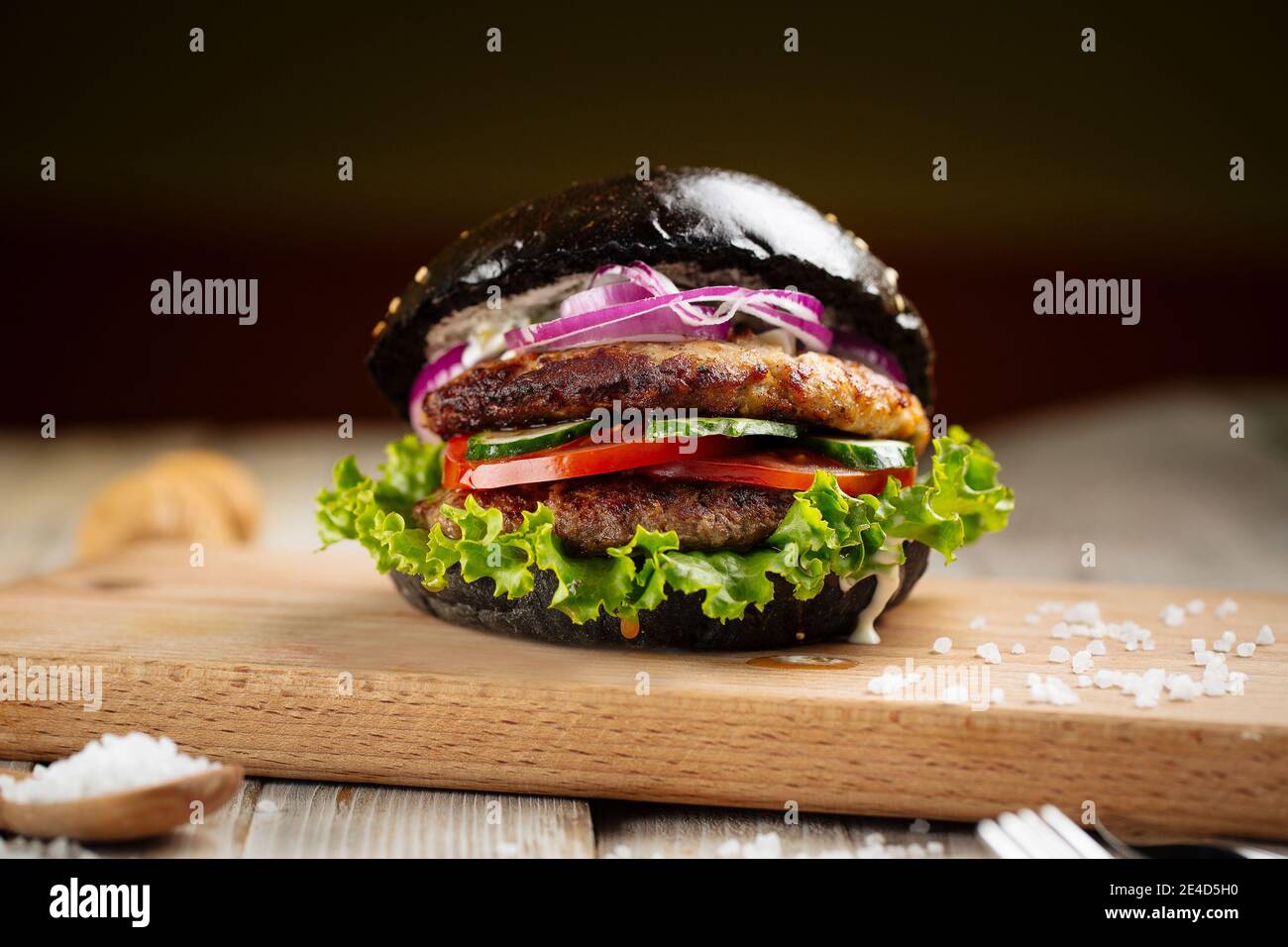 Hamburger nero doppio paty sulla tavola di legno Foto Stock