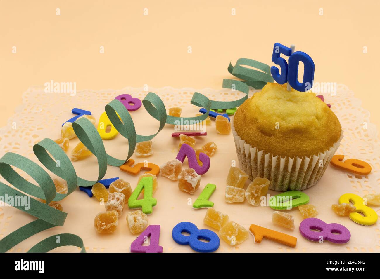 Concetto di compleanno, un cupcake con il numero 50, fagioli di gelatina e numeri di sfondo Foto Stock