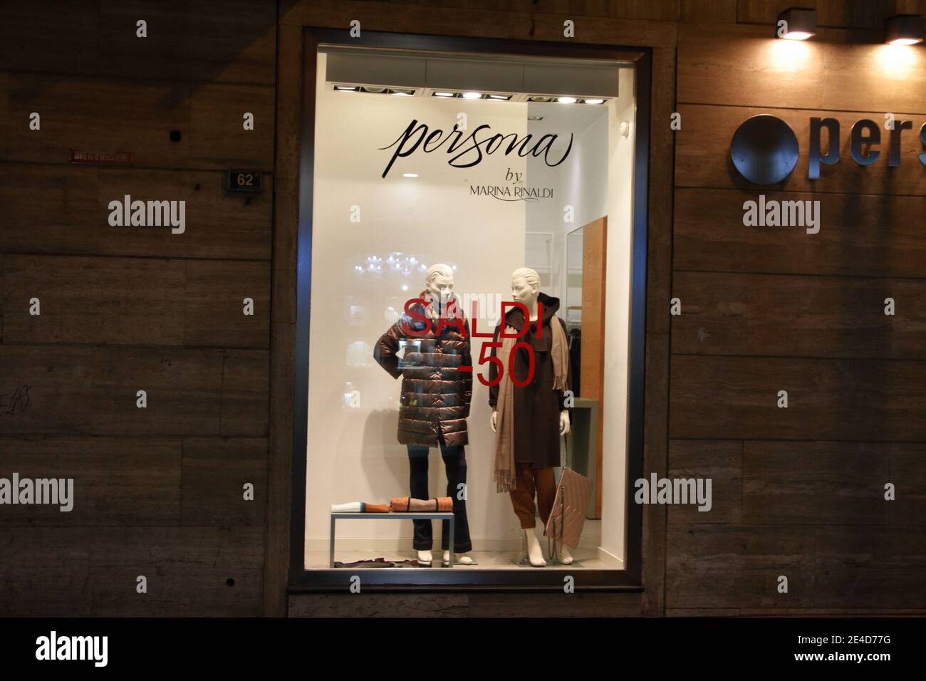 Secondo giorno dall'inizio delle vendite invernali. Pochi clienti e piccole imprese i.persone camminano con maschere di fronte al negozio con vestiti Foto Stock