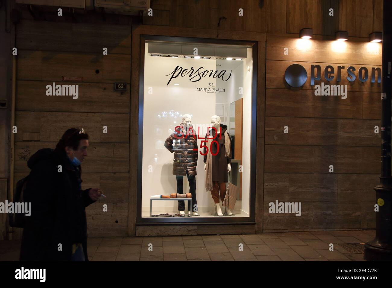 Secondo giorno dall'inizio delle vendite invernali. Pochi clienti e piccole imprese i.persone camminano con maschere di fronte al negozio con vestiti Foto Stock