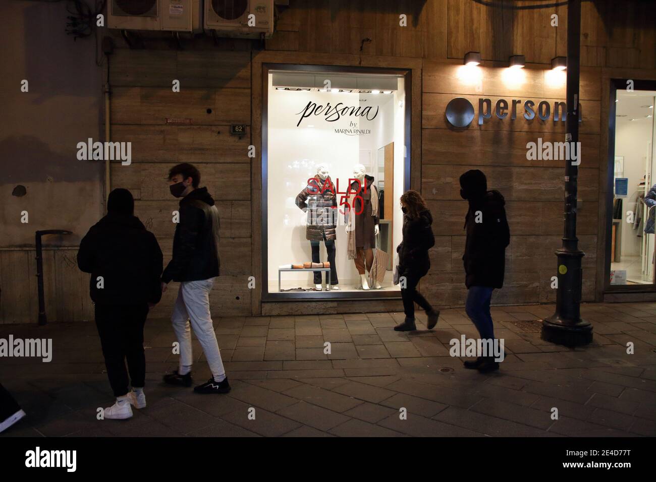Secondo giorno dall'inizio delle vendite invernali. Pochi clienti e piccole imprese i.persone camminano con maschere di fronte al negozio con vestiti Foto Stock