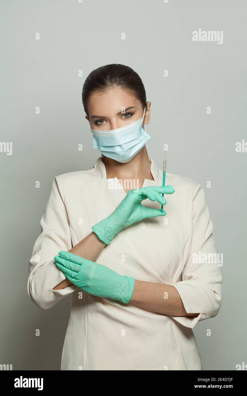 Il medico o l'infermiere che tiene la siringa e la fiala per iniezione su sfondo bianco. Medicina, cosmetologia e concetto di vaccinazione Foto Stock