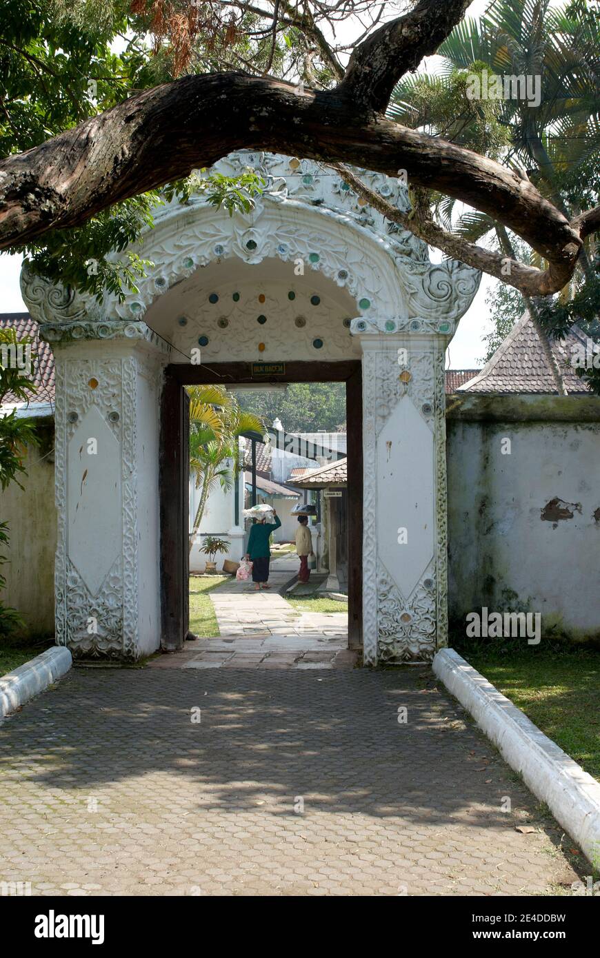 Una delle porte del palazzo di Kasepuhan Cirebon con uno stile architettonico europeo intagliato. All'interno c'erano due venditori di cibo tradizionali Foto Stock