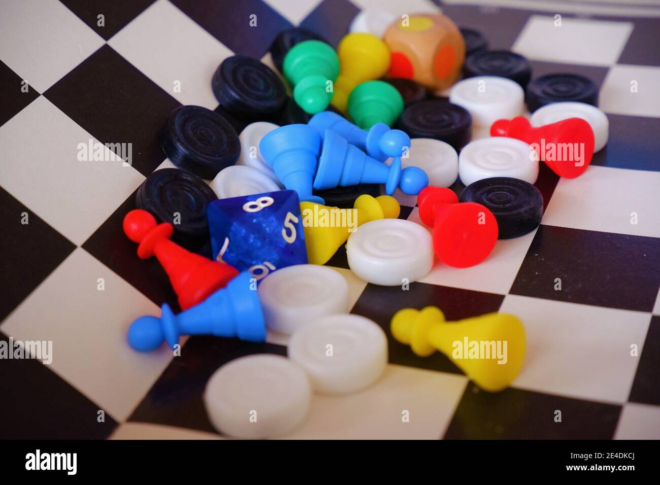 Diverse figure di gioco del social board su una scacchiera Foto Stock