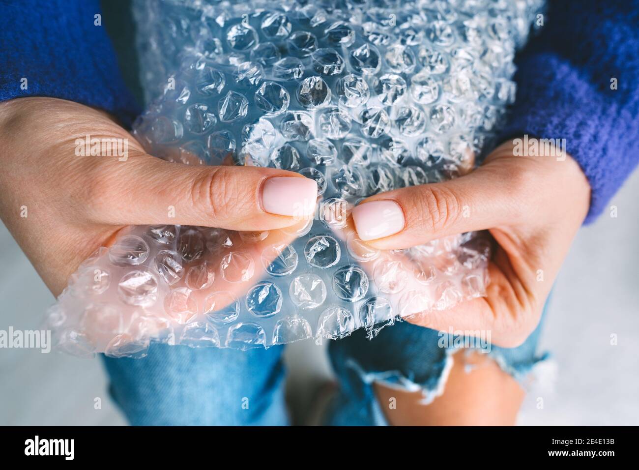 Le mani della donna schiacciano o schioccano le bolle nel wrap della bolla. Anti stress, relax Foto Stock