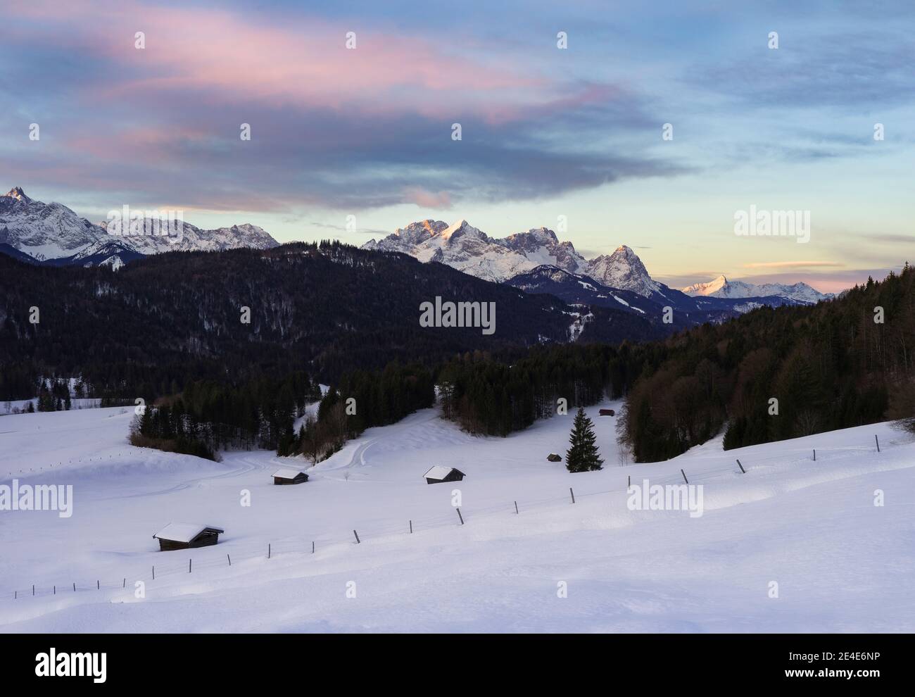 Bella alba in montagna con le capanne innevate dentro Primo piano - Alpi con Alpspitze e Zugspitze sullo sfondo Foto Stock