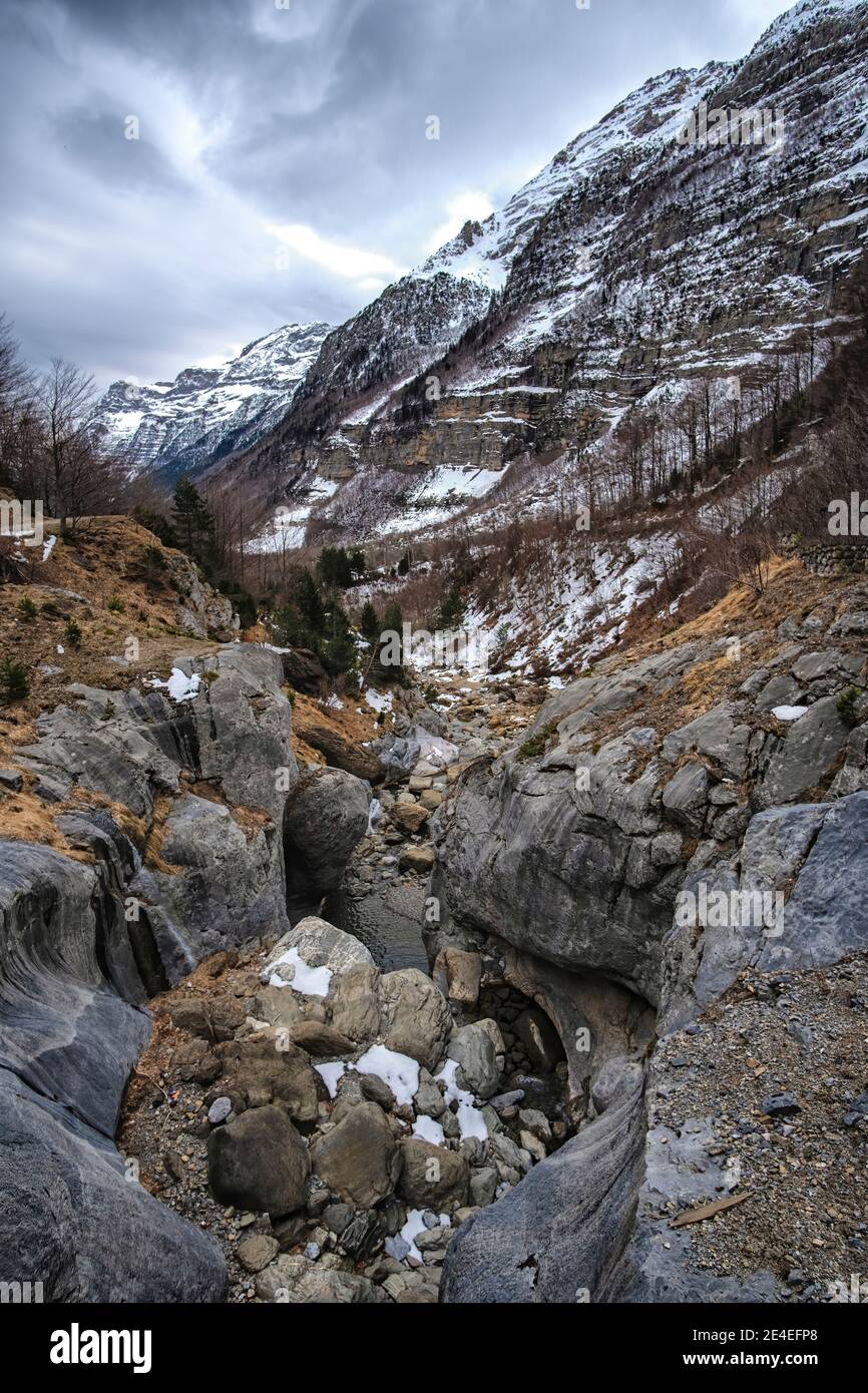Gola di montagna alla fine dell'inverno con neve nella Val di Pineta nei Pirenei aragonesi, Huesca, Spagna, verticale Foto Stock