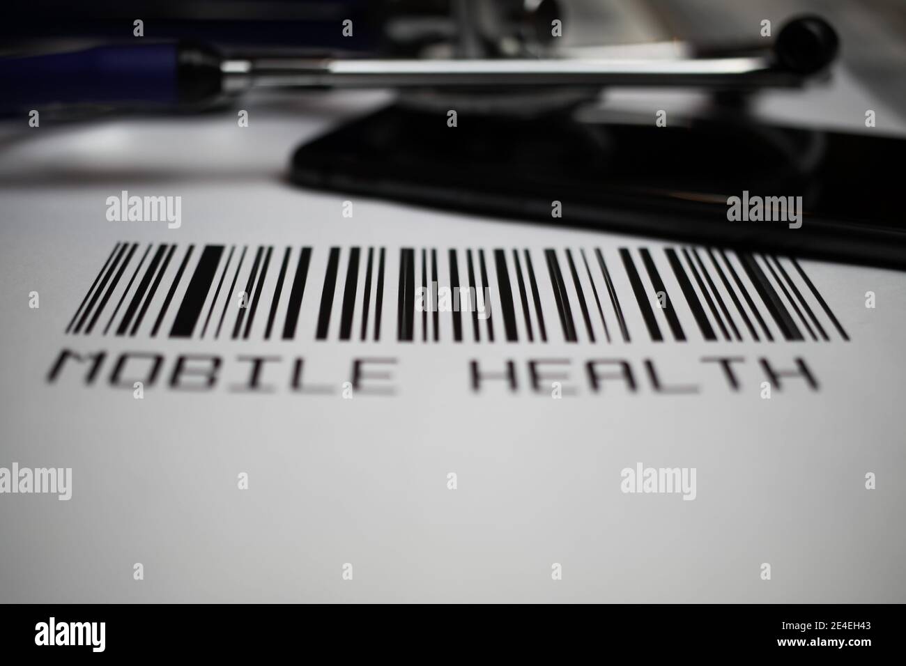 Primo piano del codice a barre fittizio con stetoscopio, smartphone e testo salute mobile, sfondo bianco Foto Stock