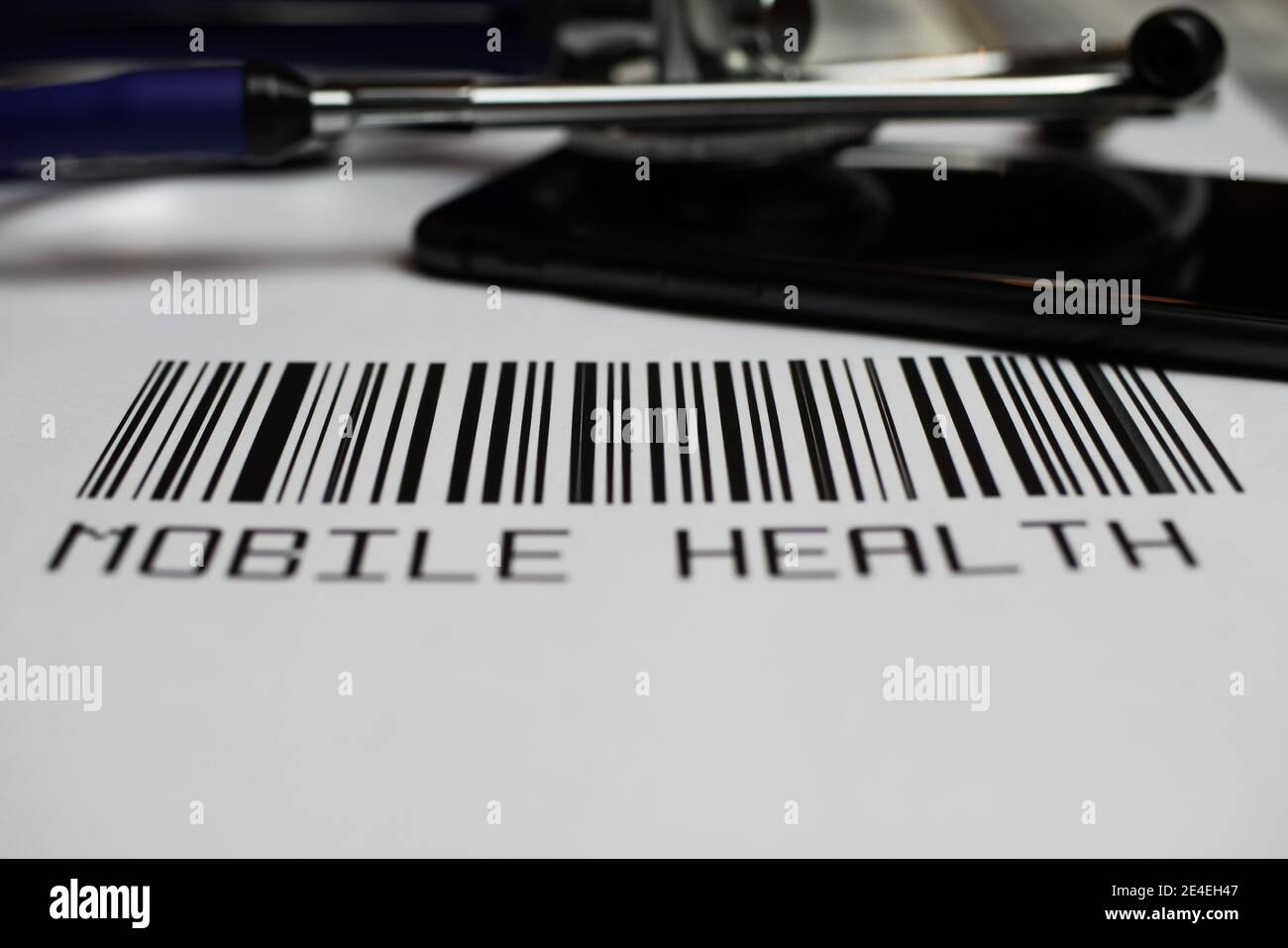 Primo piano del codice a barre fittizio con stetoscopio, smartphone e testo salute mobile, sfondo bianco Foto Stock