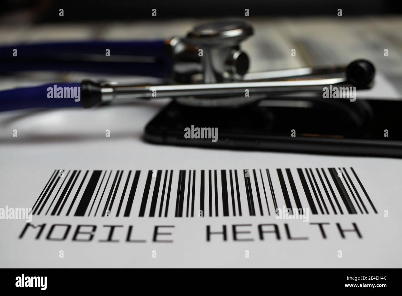Primo piano del codice a barre fittizio con stetoscopio, smartphone e testo salute mobile, sfondo bianco Foto Stock
