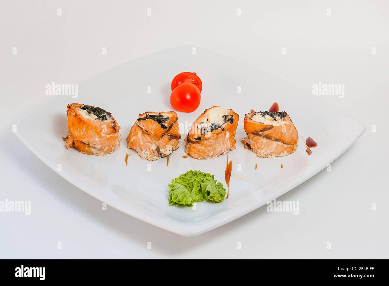 Sushi di pesce rosso e alghe. Su un piatto bianco. Foto Stock