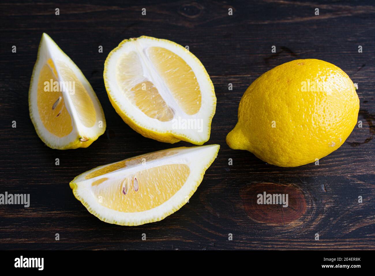 Tagliare i limoni in spicchi: Un limone intero e uno affettato Foto Stock