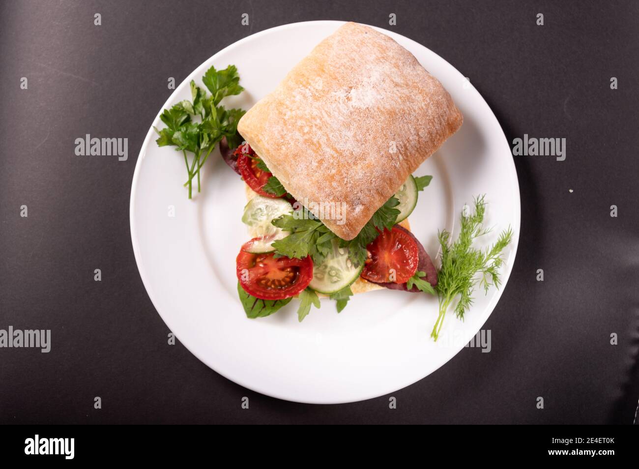 Panino Burger roll con verdure. Fare sandwich su un piatto bianco. Foto Stock