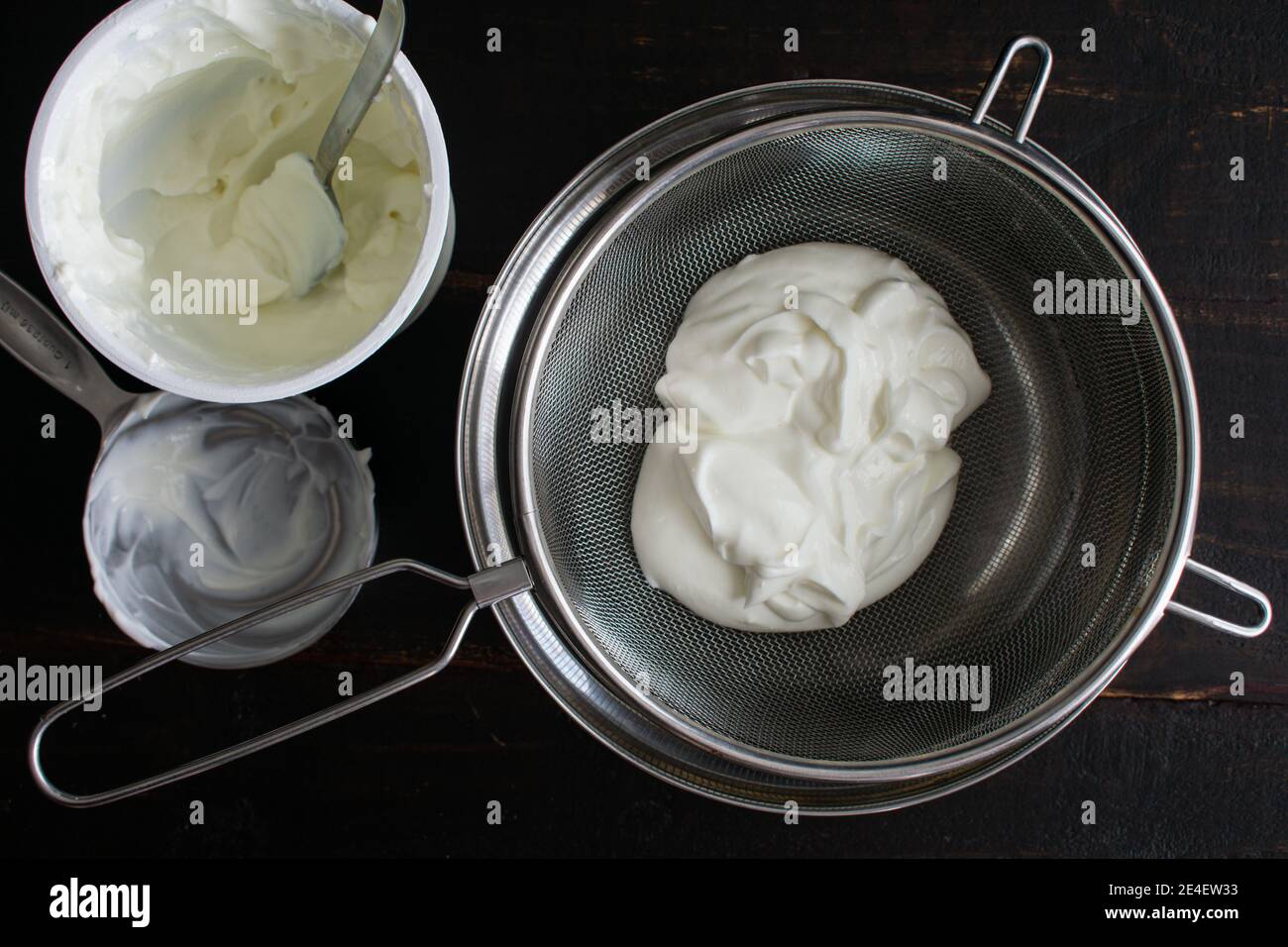 Yogurt magro in un setaccio Mesh: Yogurt in un setaccio a rete posto su un recipiente di miscelazione in modo che l'acqua possa drenare Foto Stock