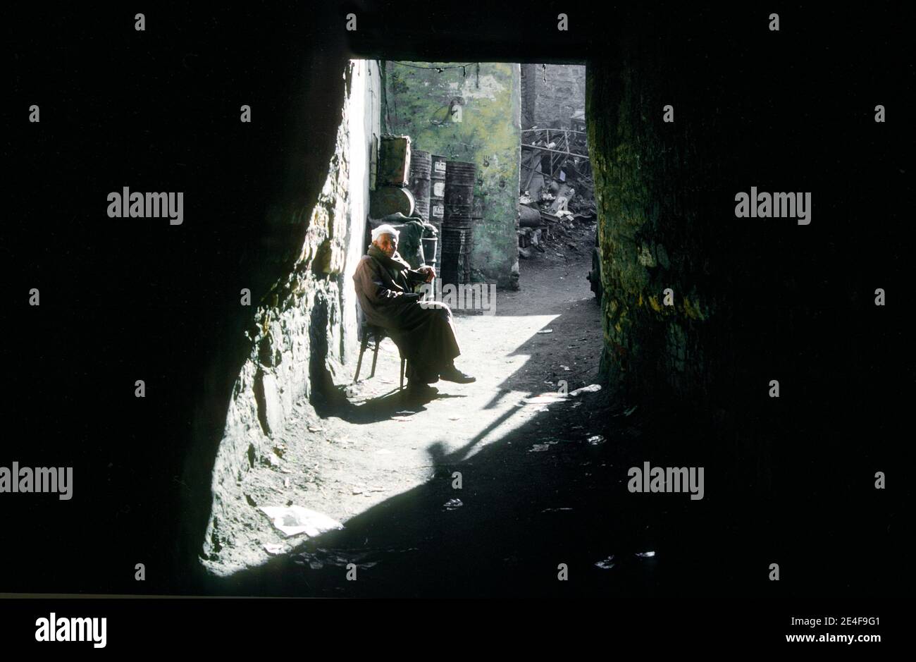 Uomo seduto nel vecchio quartiere del Cairo Egitto Foto Stock