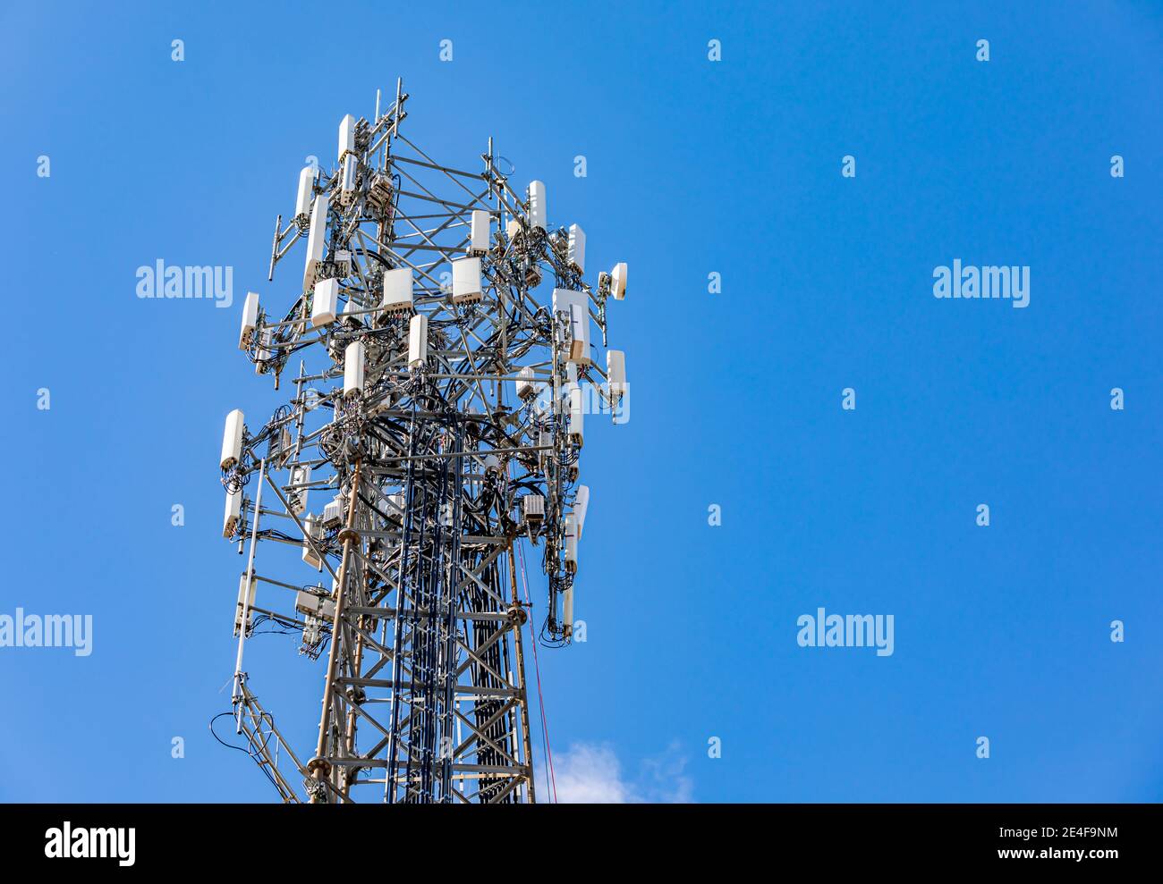 La parte superiore di una torre di un telefono cellulare contro un blu cielo Foto Stock