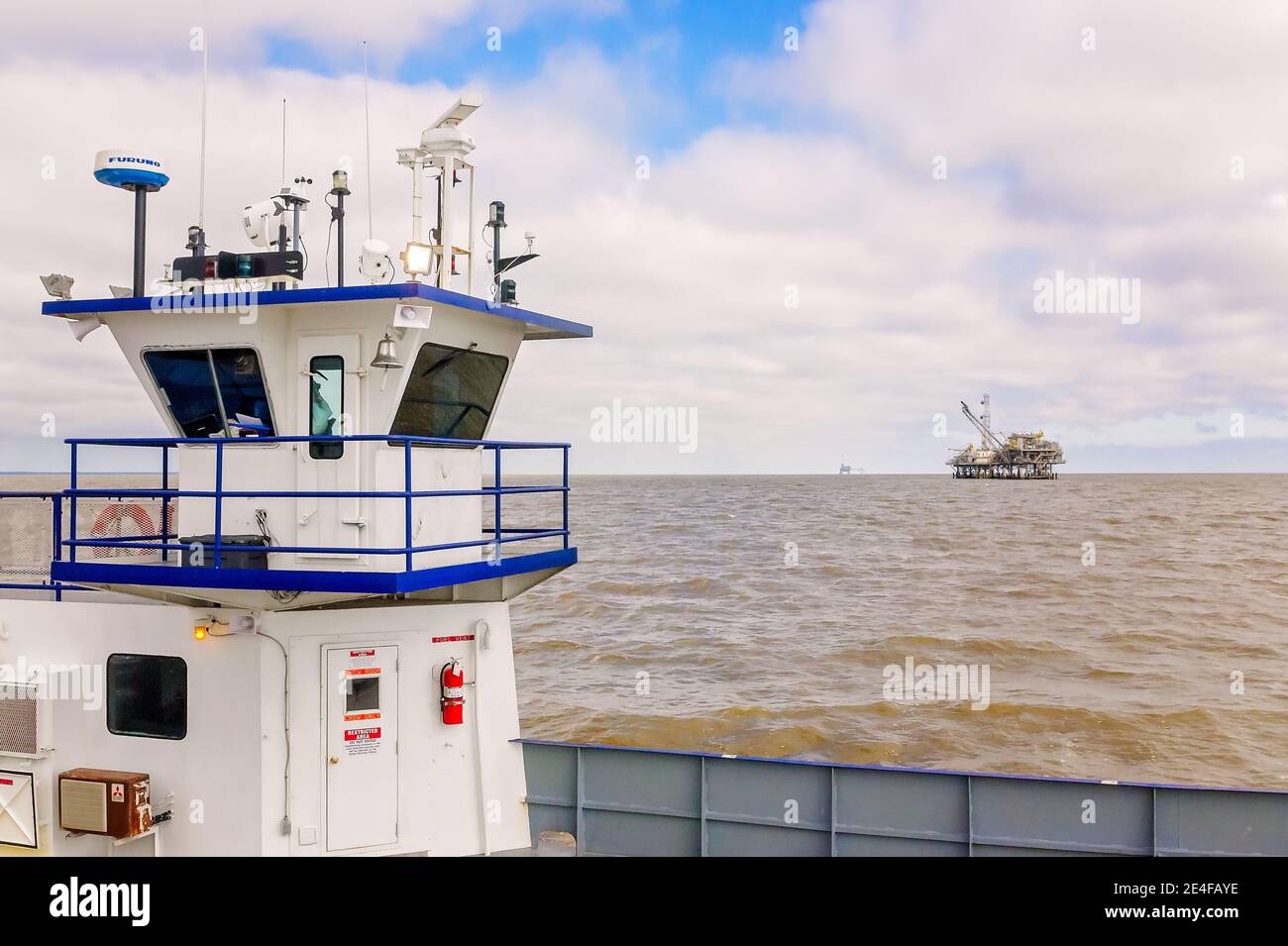 Il Mobile Bay Ferry passa davanti a un carro di perforazione a gas naturale, il 4 marzo 2016, a Dauphin Island, Alabama. HMS Global Maritime gestisce fino a due traghetti al giorno. Foto Stock