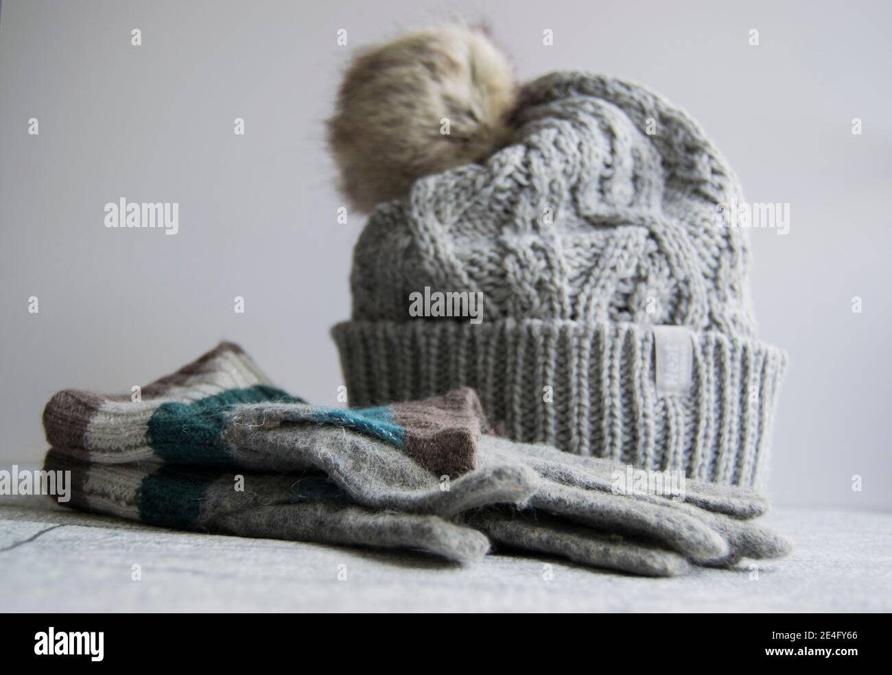 Accogliente cappello a bobina in filo grigio con guanti Foto Stock