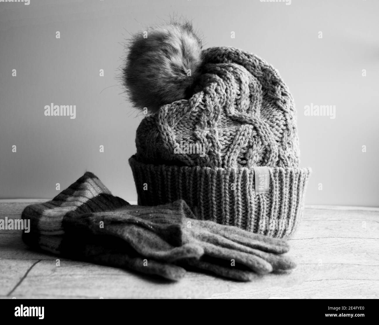 Accogliente cappello a bobina in filo grigio con guanti Foto Stock