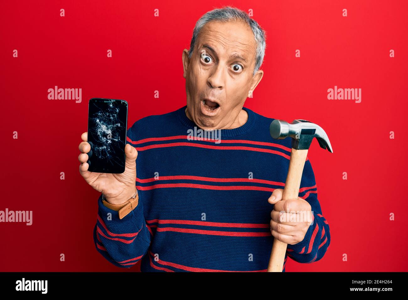 Uomo ispanico anziano che tiene rotto smartphone mostrando schermo rotto e  martello in faccia shock, guardando scettico e sarcastico, sorpreso con  aperto mo Foto stock - Alamy