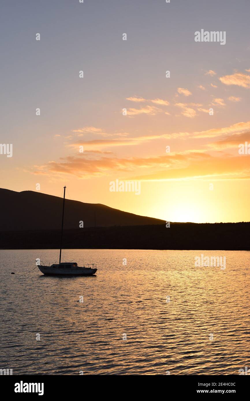 Il sole tramonta dietro una barca a vela sul porto di Molino Viejo, vicino a San Quintin, Baja California, Messico Foto Stock