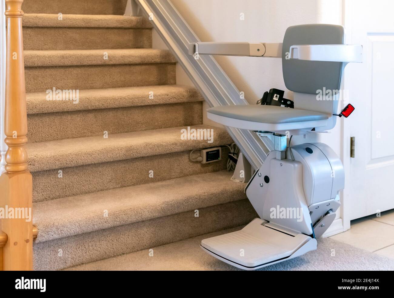 Una sedia elettrica motorizzata per persone con disabilità su una scala in  moquette in una casa residenziale Foto stock - Alamy