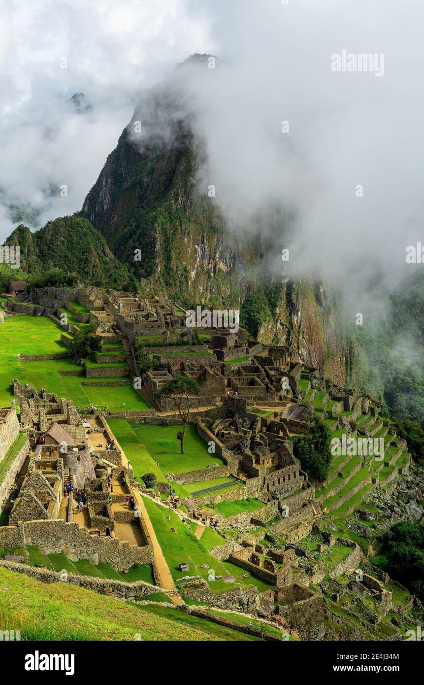 Vertical Machu Picchu Inca rovina nella nebbia, Cusco, Perù. Foto Stock