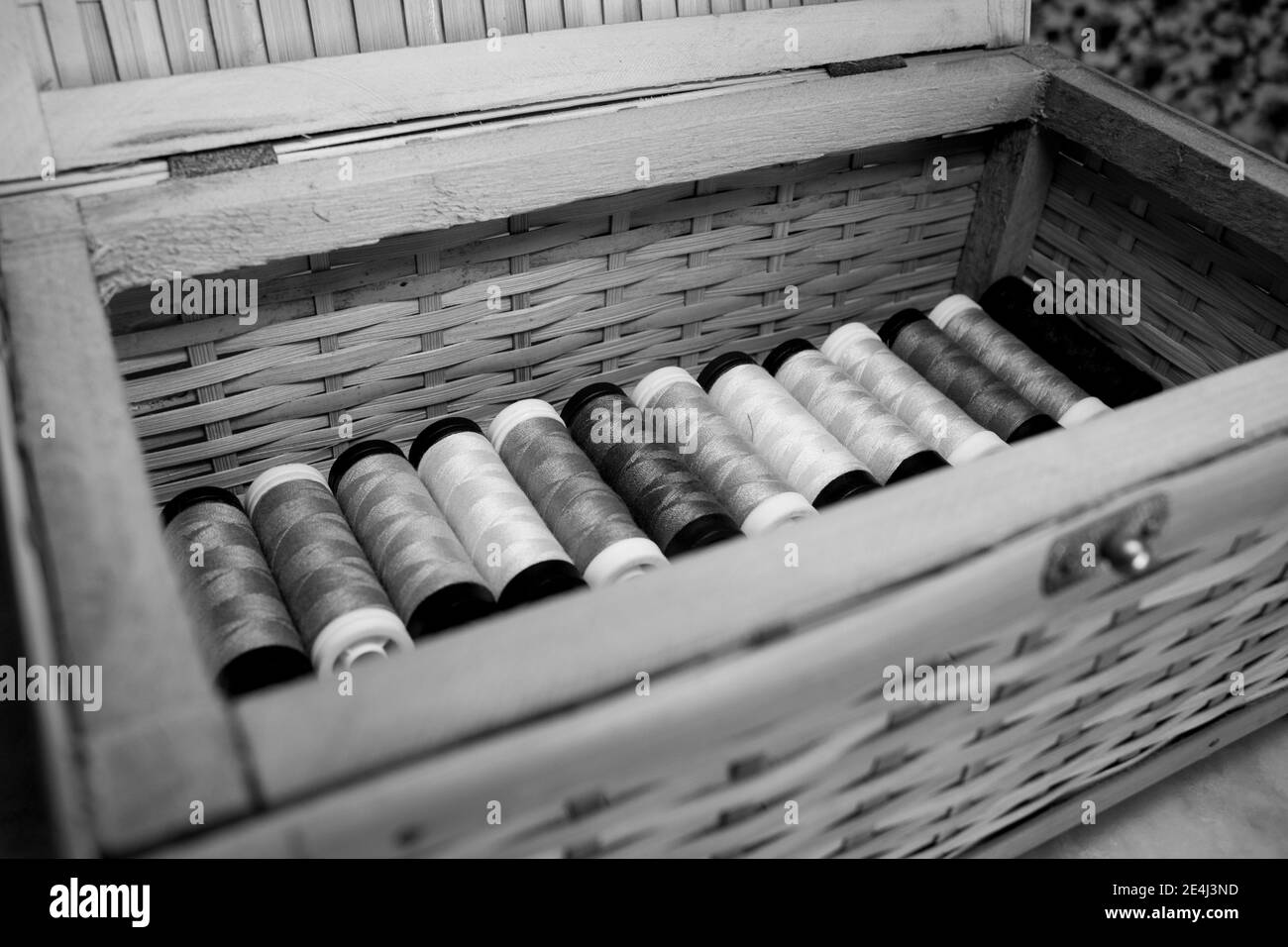 Scatola in legno piena di bobine filettate multicolore [Bianco e nero versione] Foto Stock
