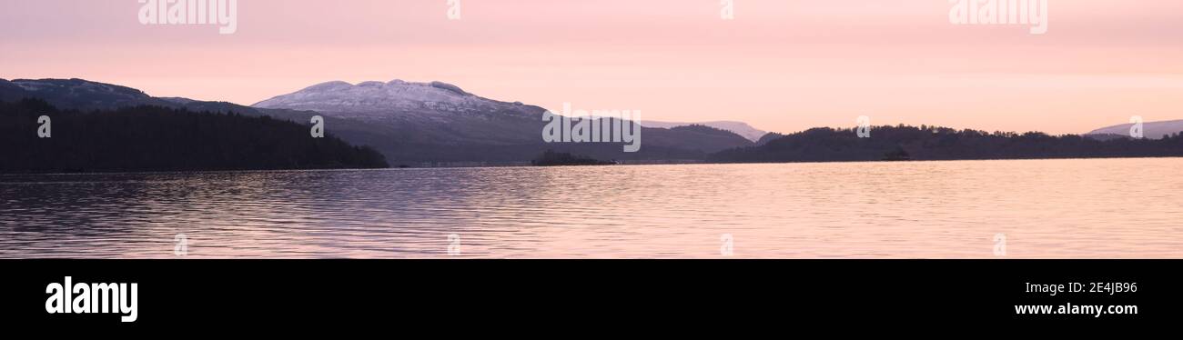 Ben Lomond a Loch Lomond durante il cielo rosa dell'alba Scozia Foto Stock