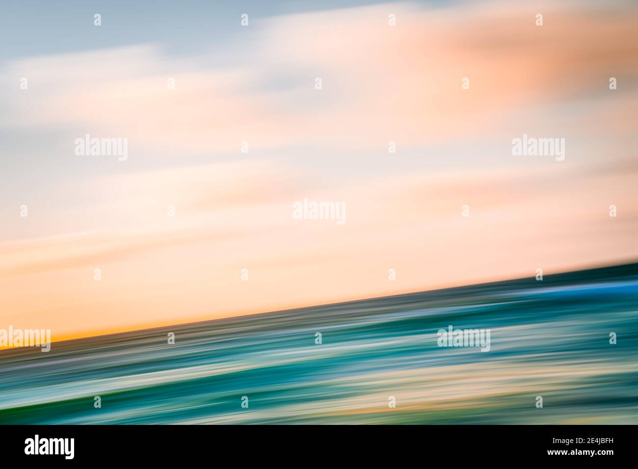 Tramonto rosa sul mare sfondo astratto. Acqua color turchese e bellissimo cielo nuvoloso, esposizione lunga, sfocatura del movimento Foto Stock
