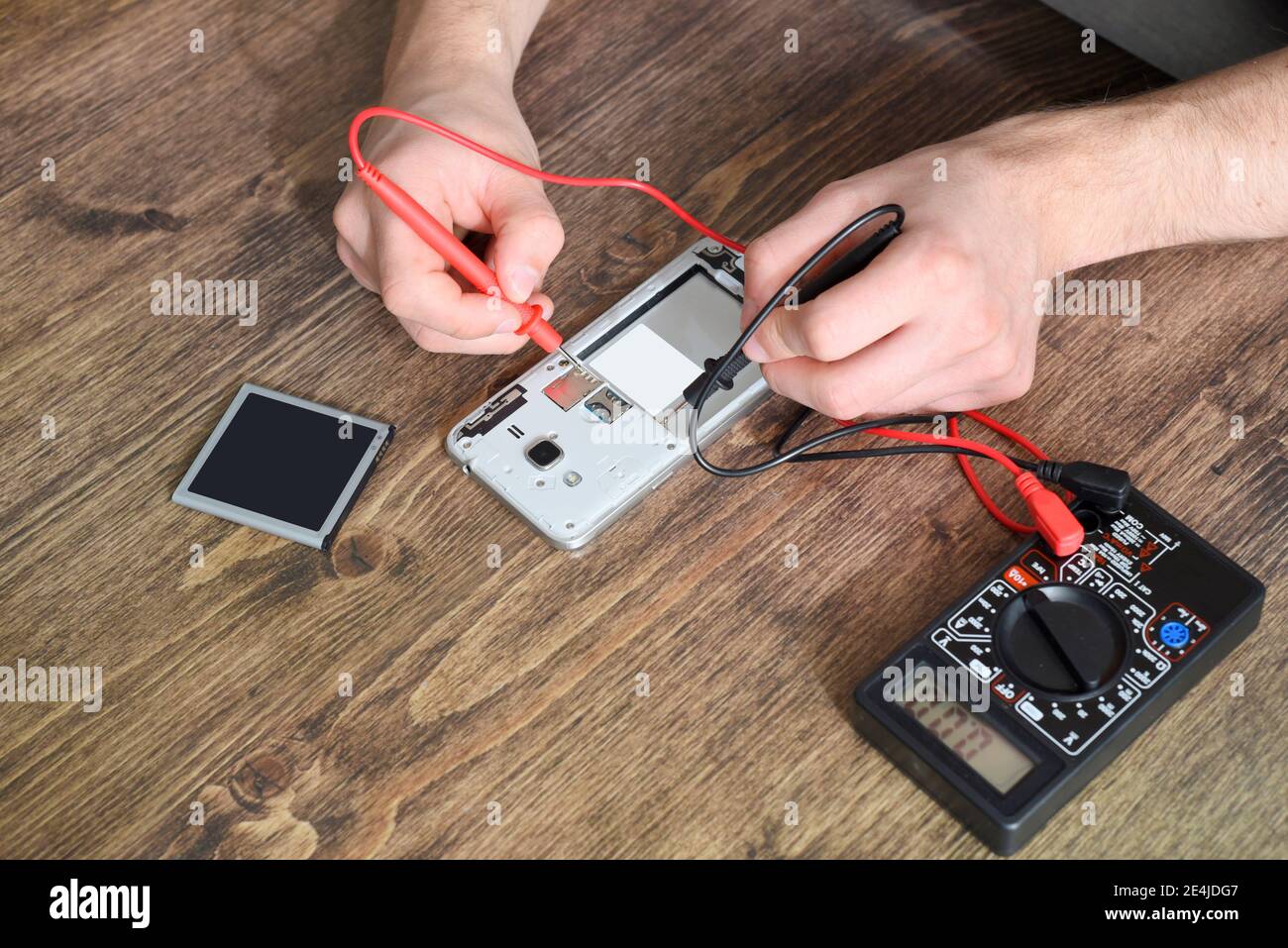 Concetto di riparazione del telefono. Controllo con un multimetro Foto Stock