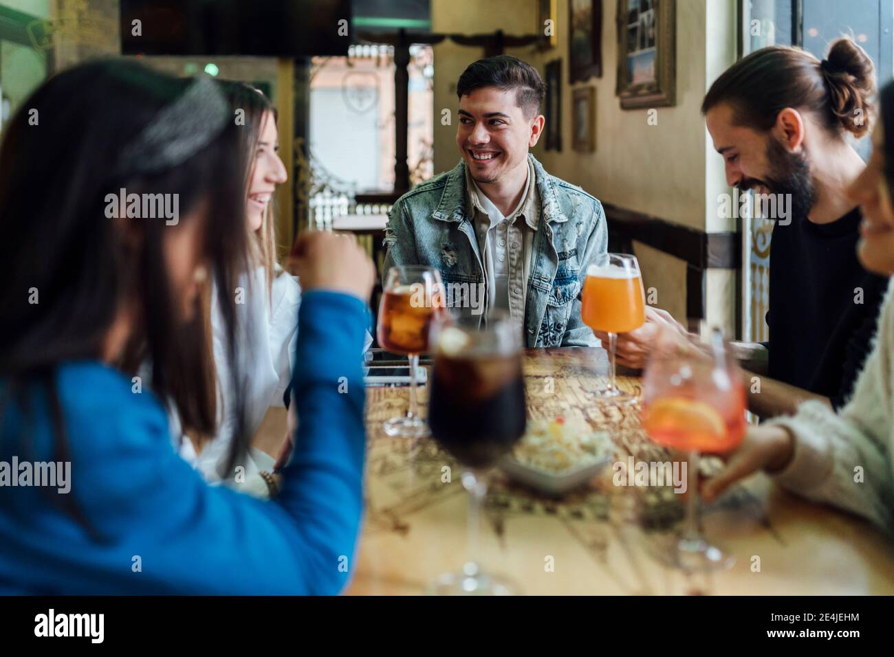 Gli amici trascorrono del tempo libero mentre bevono un drink al bar Foto Stock